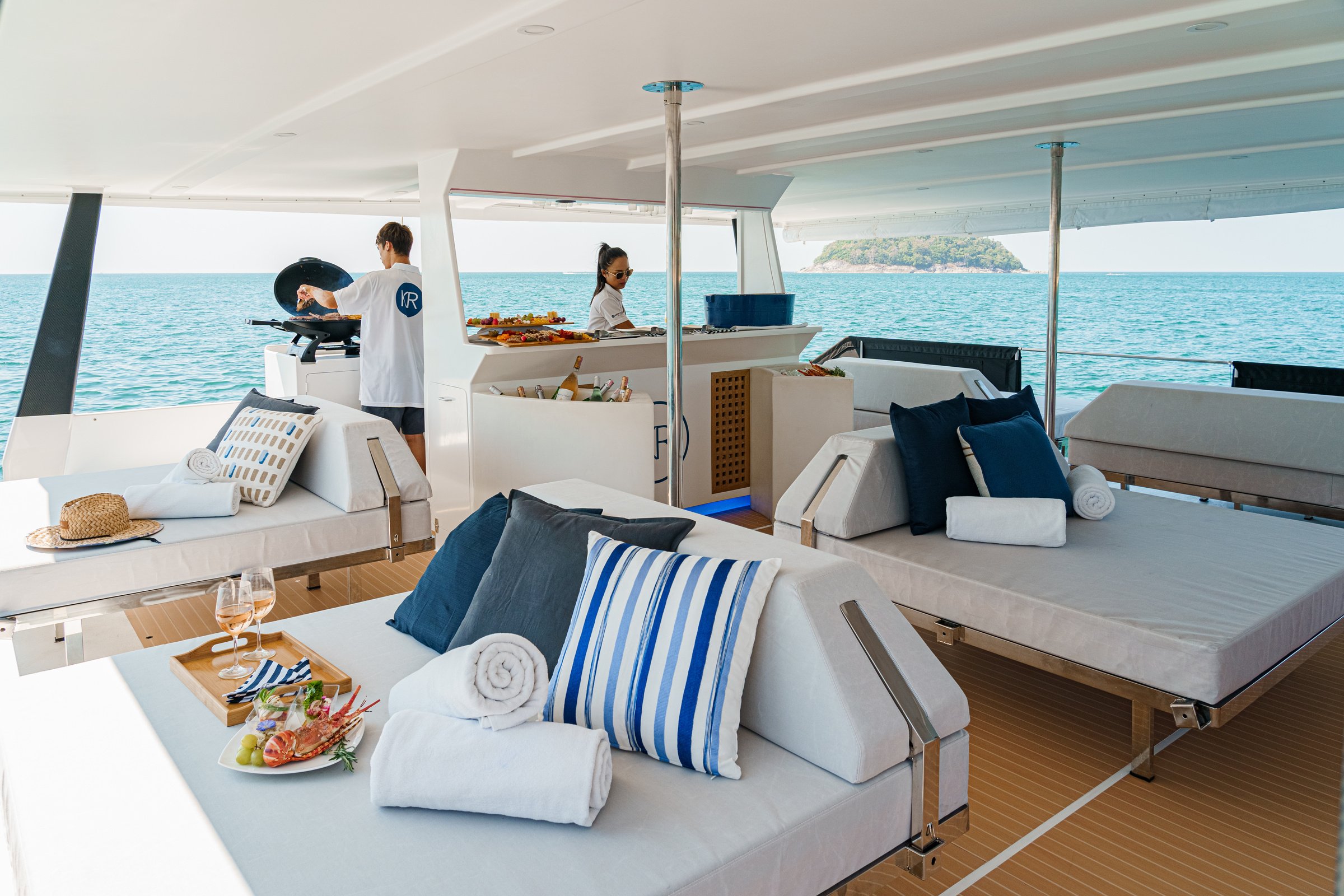 the interior of a catamaran with beds and pillows