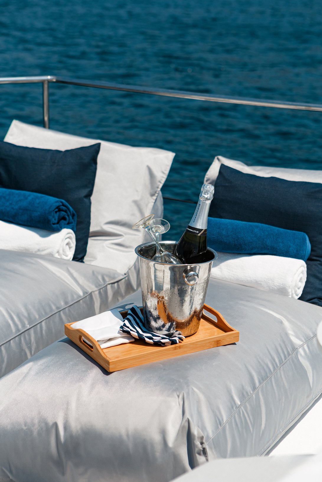 two pillows and a bottle of champagne on the deck of a boat