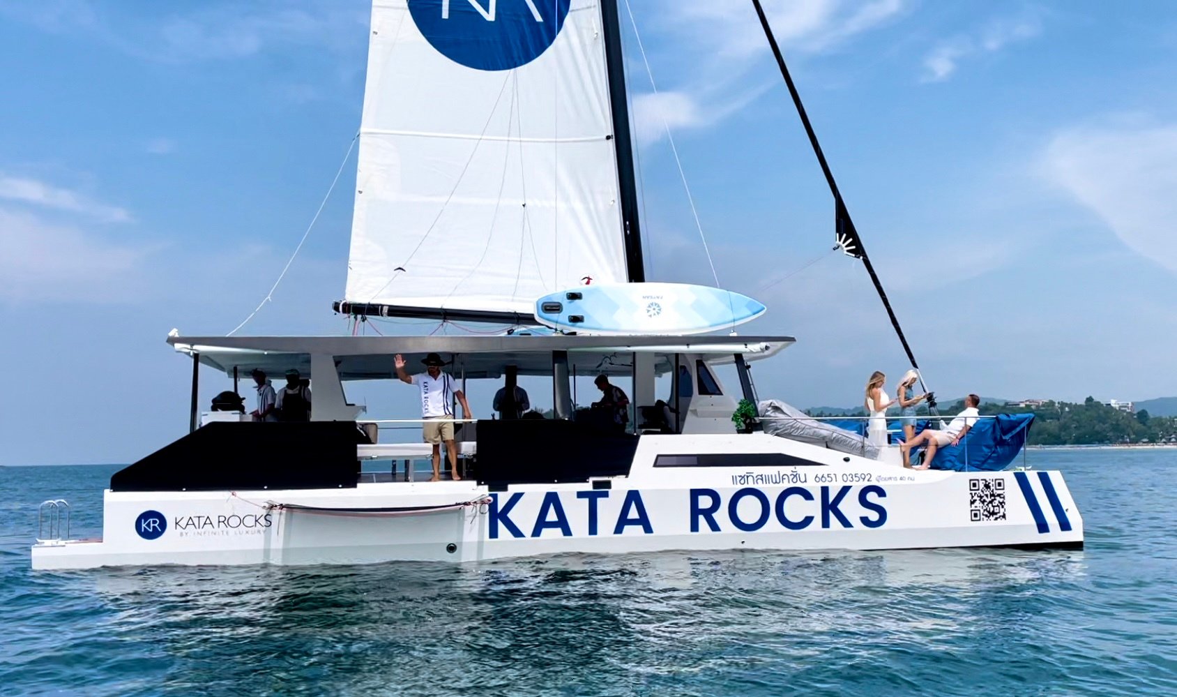 a sailing catamaran with people on it in the ocean. ready for a wonderful cruise or sunset. Let's have fun on the sea with KR catamaran